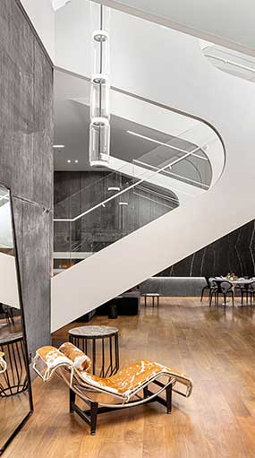 Modern interior staircase with sleek glass and white design.