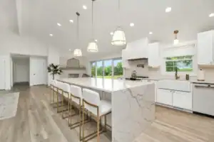 Bright, contemporary kitchen with white cabinetry and marble island.
