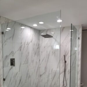 Luxury walk-in shower with marble tiles and modern fixtures.