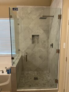 Customized walk-in shower with frameless glass and elegant tile design.