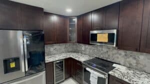 Sleek kitchen with custom cabinetry, granite countertops, and stainless steel appliances for home renovation.