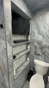 Bathroom remodeling featuring high-end marble finishes and built-in shelving.