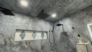 Bright, stylish bathroom featuring marble tile walls, rain showerheads, and contemporary design elements.