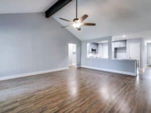 Bright, modern living room with open kitchen design and hardwood floors. Expert home renovation by Salvation Home Remodeling.