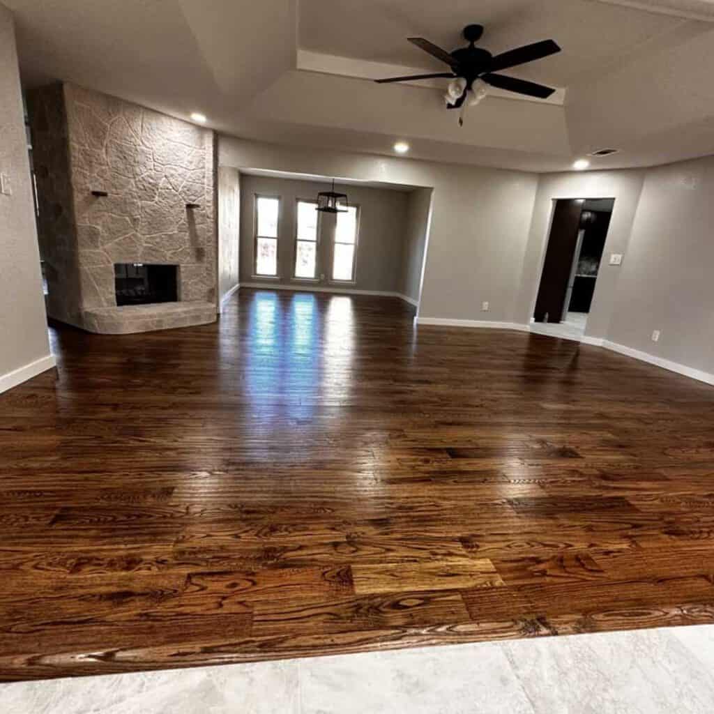 Spacious living area featuring hardwood floors, a fireplace, and large windows for natural light | Expert home remodeling by Salvation Home Remodeling emphasizes quality and style.