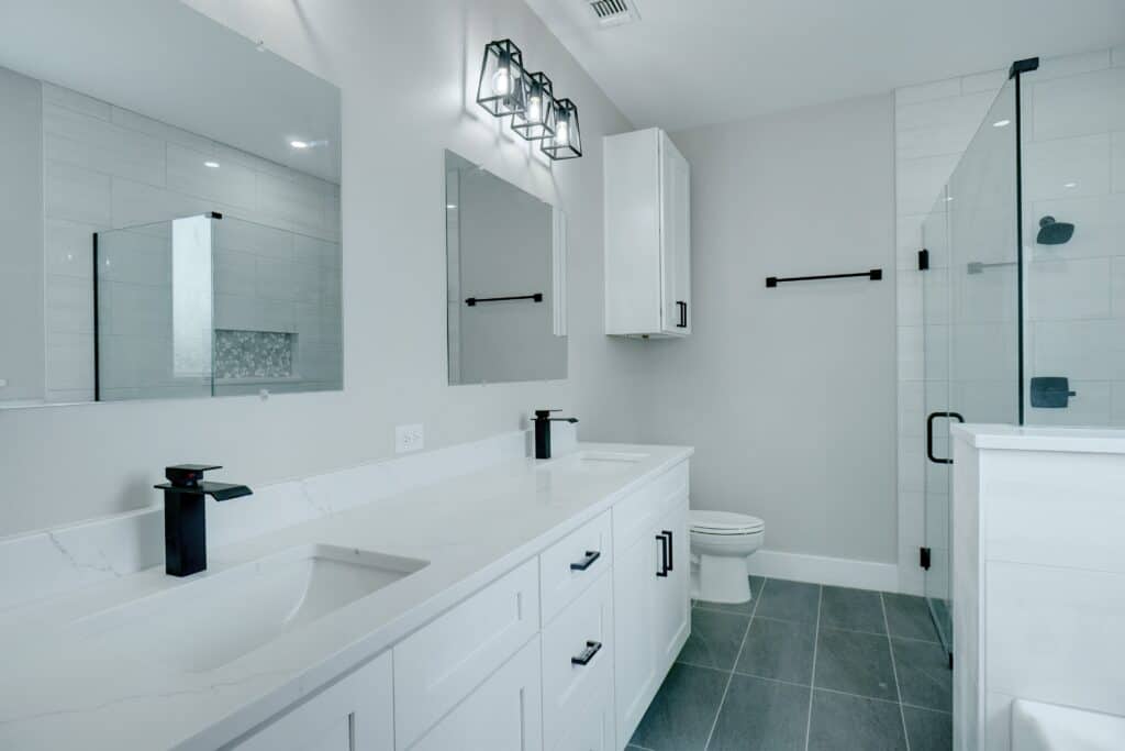 Bright, sleek bathroom featuring contemporary design, double vanity, and walk-in shower.