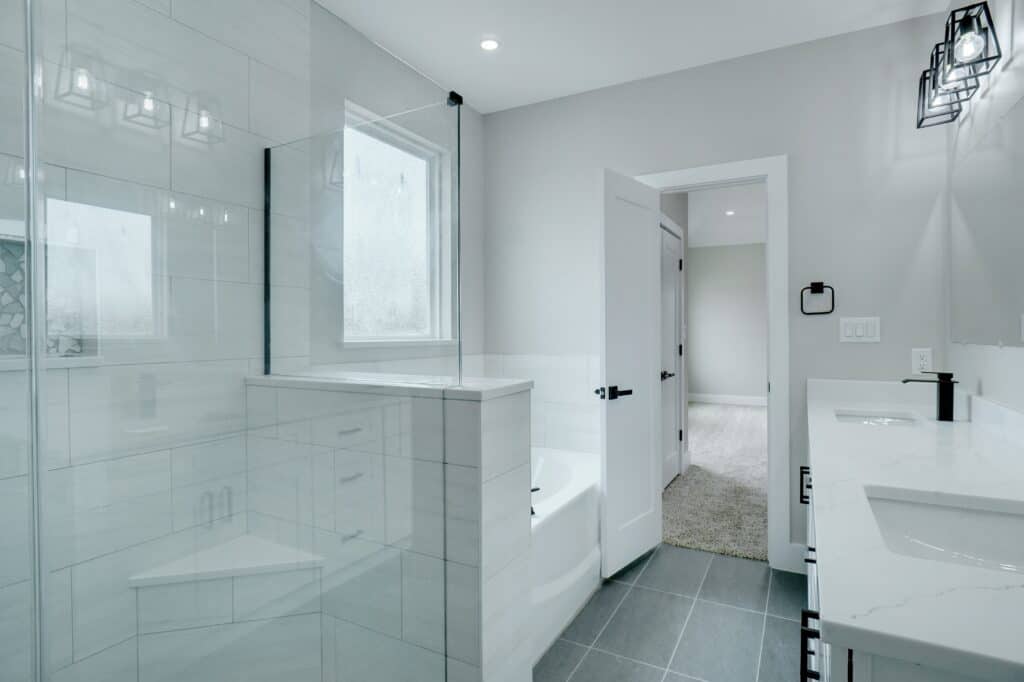 Bright, clean bathroom with white tiles, double sink, and contemporary fixtures.