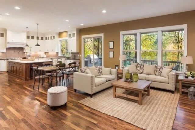Bright, modern living room with spacious open plan, stylish furniture, and large windows showcasing nature.