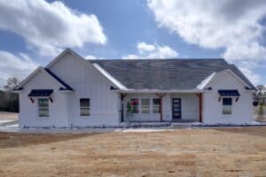 Spacious house with contemporary design, white siding, and stylish black window awnings in a new residential project.