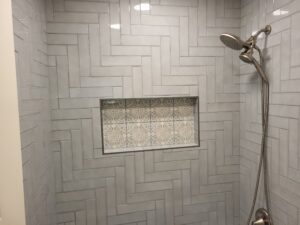 High-quality tiled shower with built-in niche and modern fixtures.
