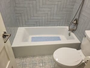 Stylish bathroom renovation featuring gray subway tiles and updated fixtures.