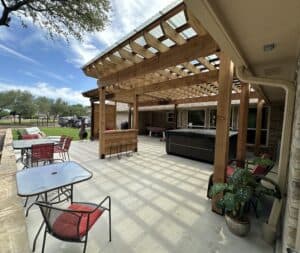 Backyard covered patio with wooden pergola and outdoor living space.