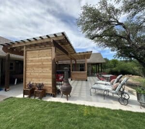 Stylish backyard patio featuring a custom wooden shade structure, outdoor seating, and renovation upgrades.