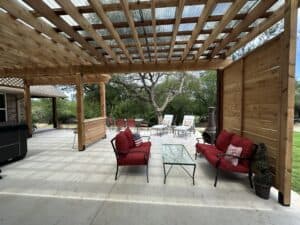Inviting outdoor living space featuring a wooden pergola, cozy seating, and backyard relaxation area under home renovation.
