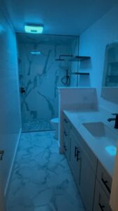 Bright and stylish bathroom remodel featuring marble tiles and contemporary design elements.