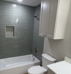 Bright, stylish bathroom with tiled shower, bathtub, and contemporary fixtures.