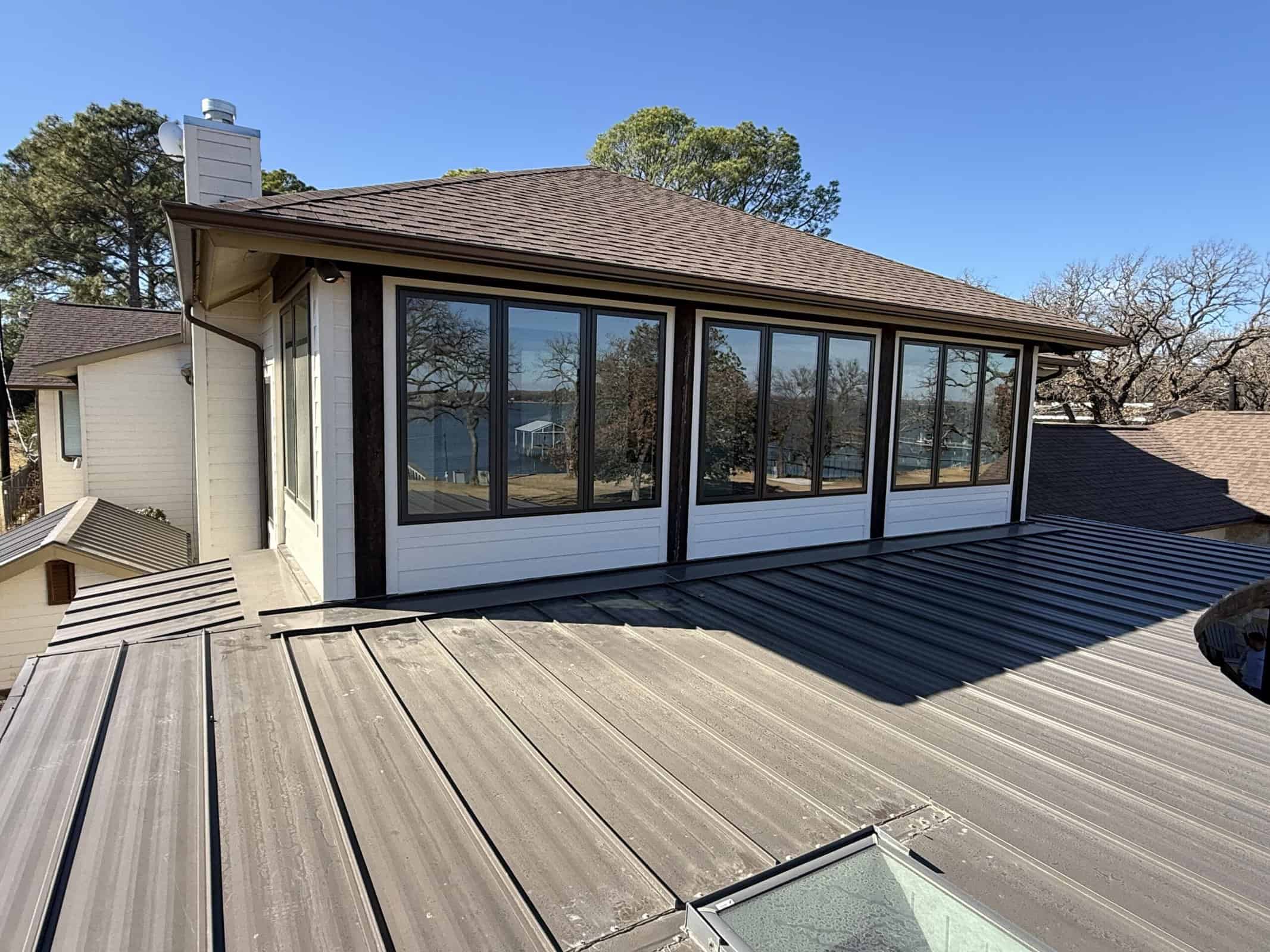 Bright home addition featuring expansive glass sunroom in backyard.