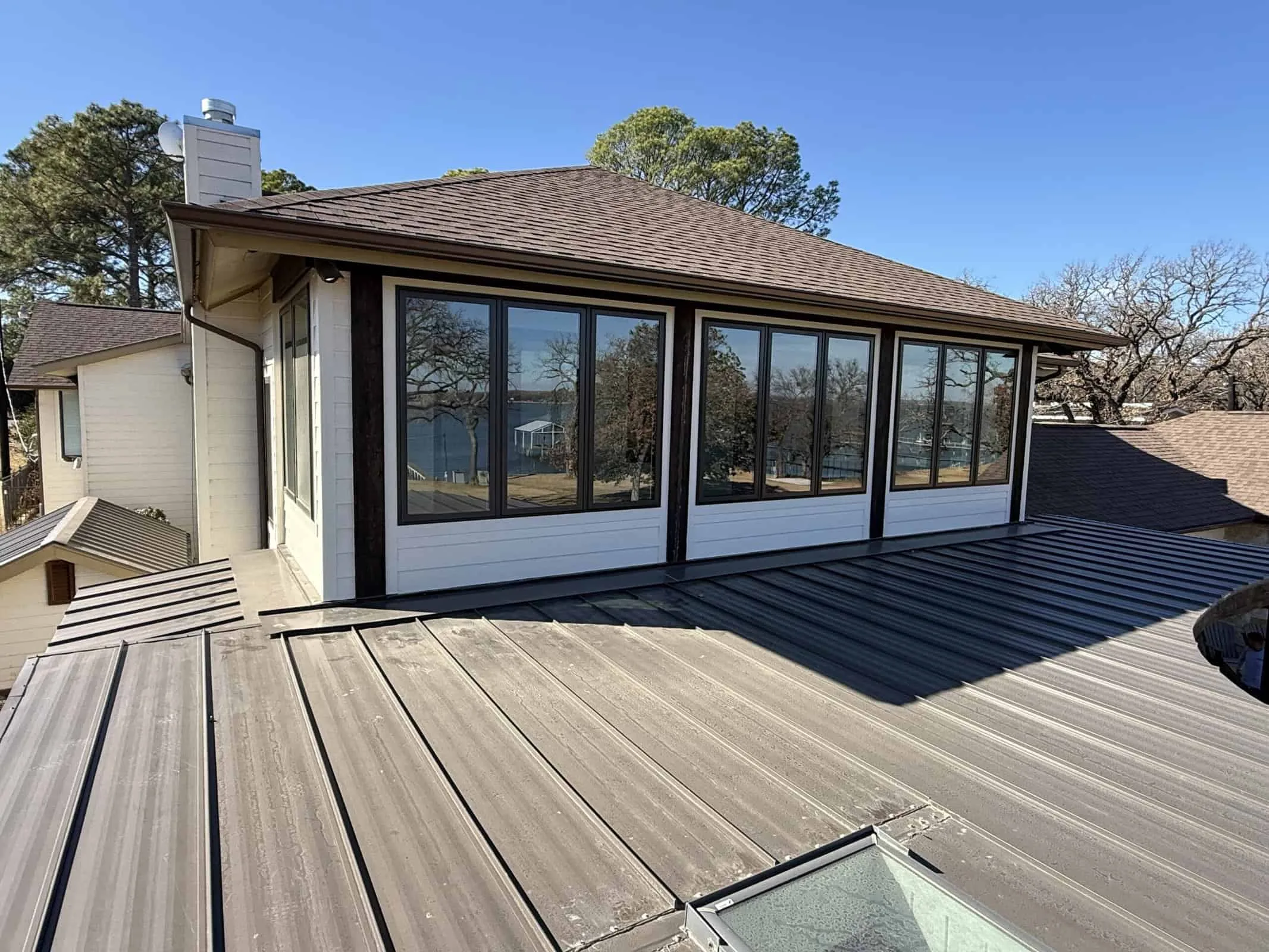 Bright home addition featuring expansive glass sunroom in backyard.
