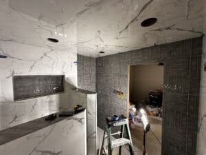 High-end marble kitchen backsplash and flooring installation during home renovation project.