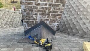 Chimney repair with roofing tools and shingles for home improvement by Salvation Home Remodeling.