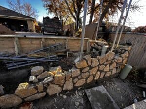 Construction site showcasing stone wall and ongoing home remodeling project.