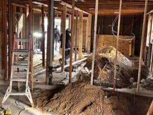 High-resolution image showing ongoing home remodeling with plumbing and framing work.
