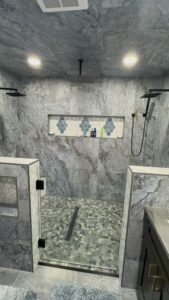 Luxurious marble shower with gray tones and elegant tile accents.