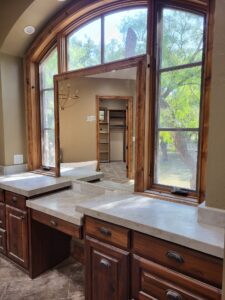 Custom kitchen with large arched windows and natural wood trim.