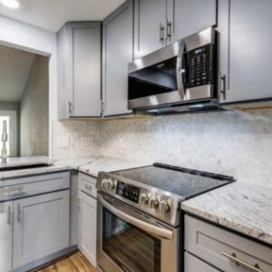 Modern kitchen with stainless steel appliances and gray cabinetry.