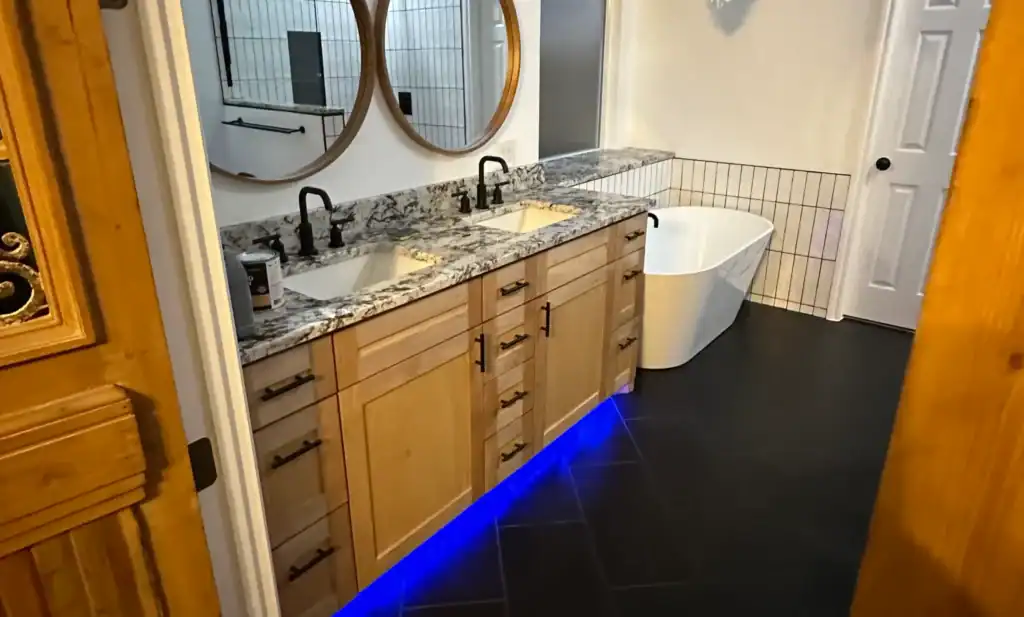 Elegant bathroom renovation featuring dual vanities with marble countertops and contemporary fixtures.
