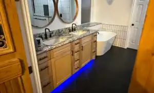 Elegant bathroom renovation featuring dual vanities with marble countertops and contemporary fixtures.