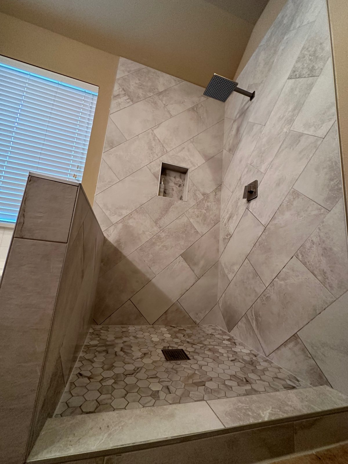 Completed walk-in shower with custom tile from a bathroom remodel by Salvation Home Remodeling