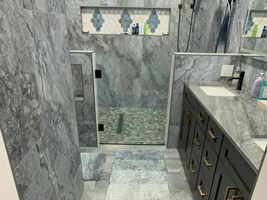 Custom tile walk-in shower with mosaic niche and pebble floor — bathroom remodel by Salvation Home Remodeling