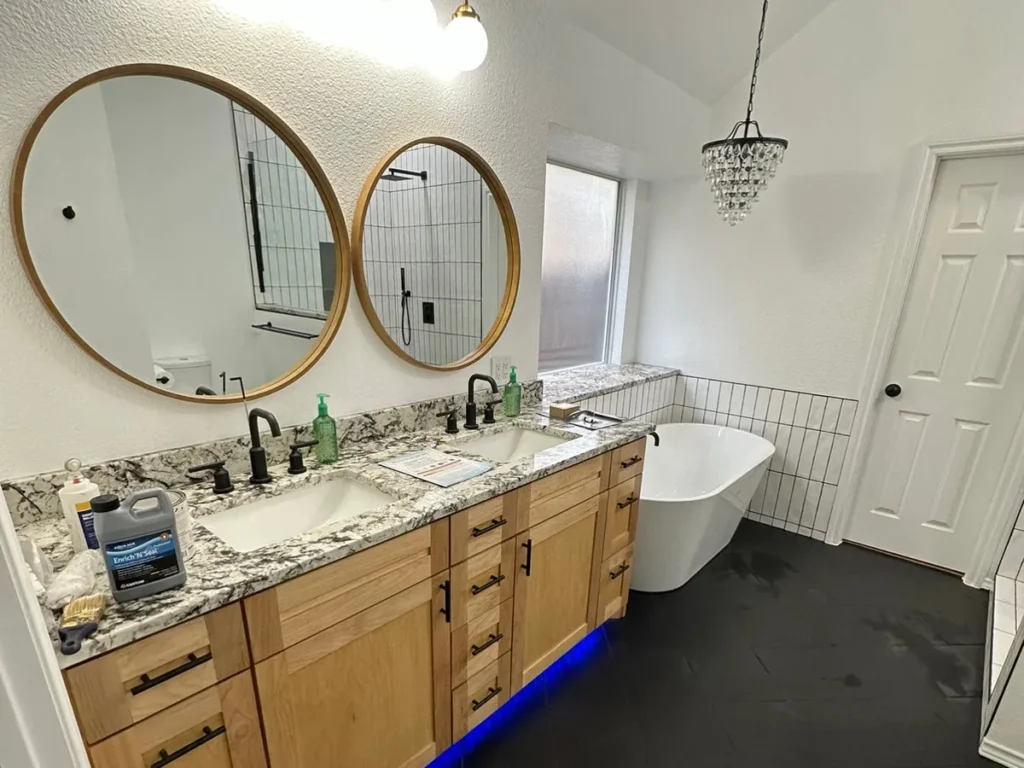 Completed master bathroom remodel — custom double vanity, freestanding tub, and tile flooring by Salvation Home Remodeling