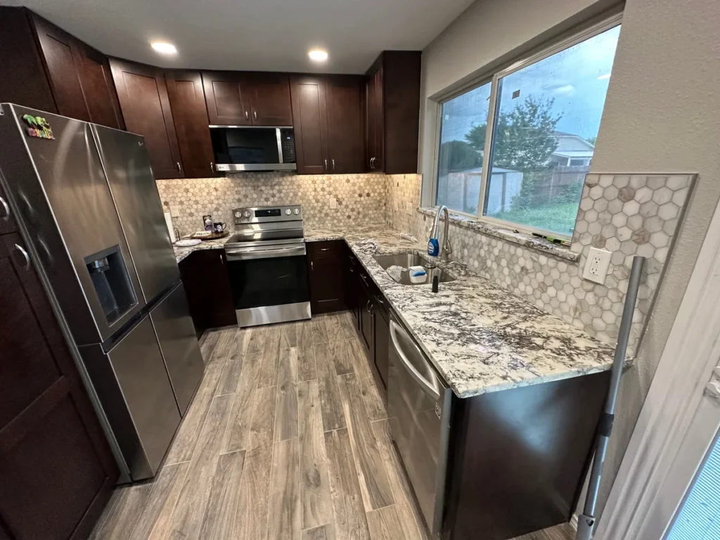 Completed kitchen remodel — dark shaker cabinets, granite counters, mosaic backsplash by Salvation Home Remodeling