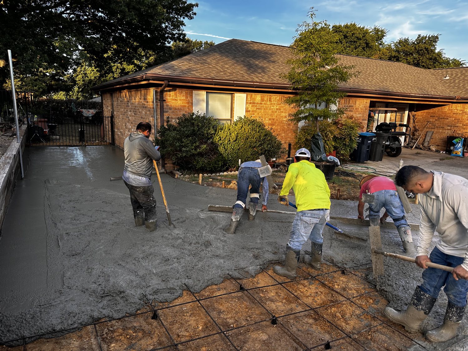 Salvation Home Remodeling crew screeding wet concrete on a Fort Worth driveway replacement.