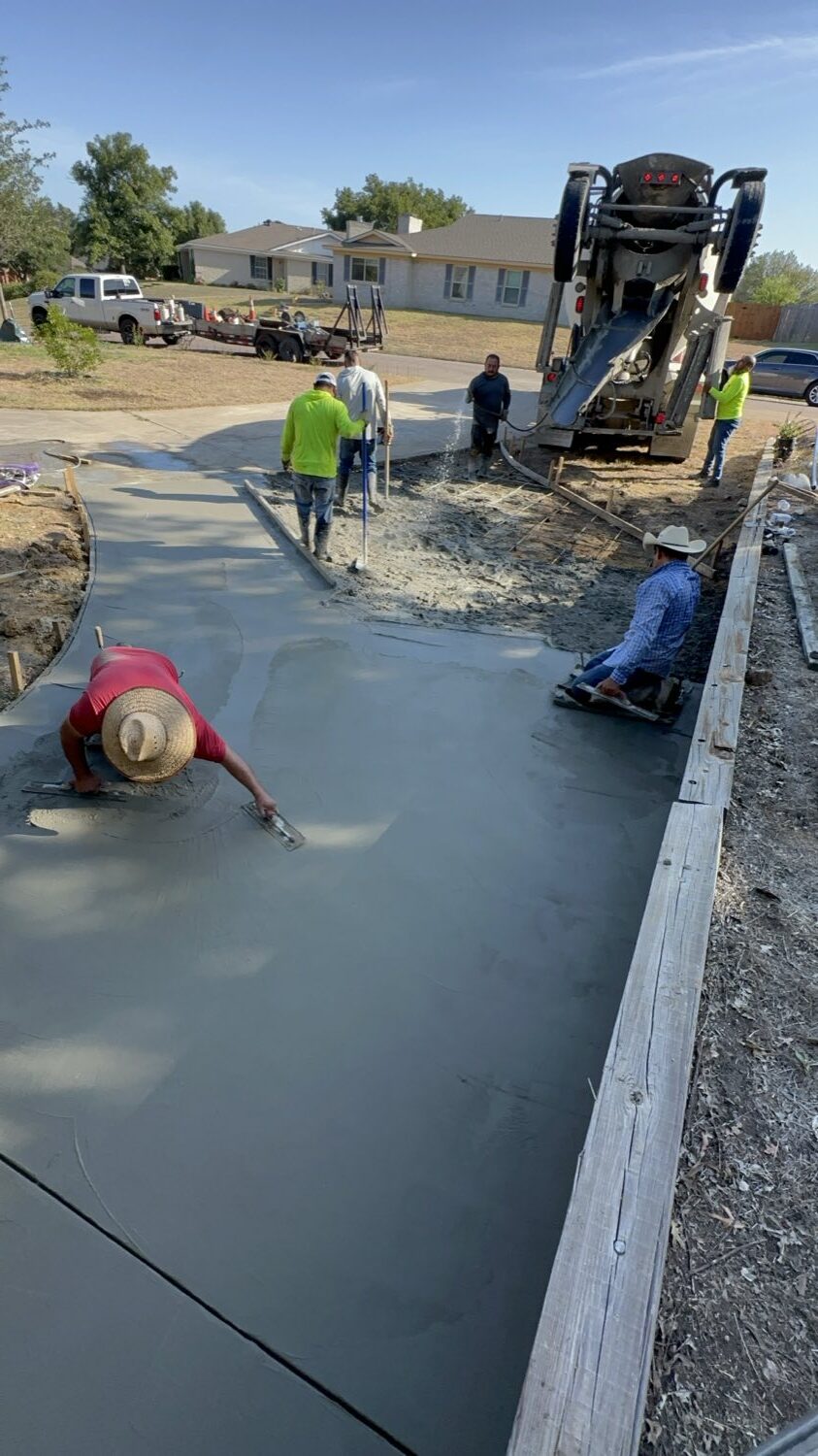 Hand-finishing the long run of a replacement concrete driveway in Fort Worth.