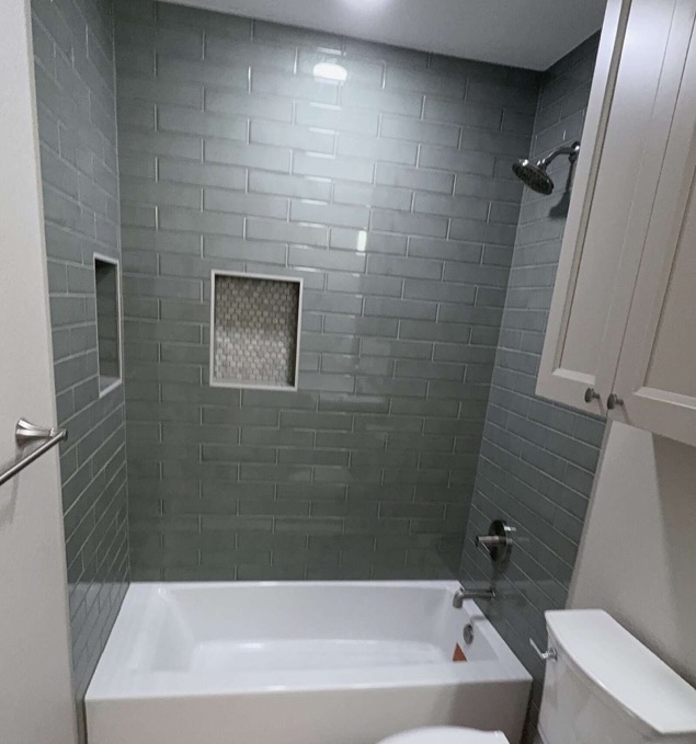Finished bathroom remodel in Fort Worth with a grey subway tile tub surround, built-in shower niche and mosaic accent tile.